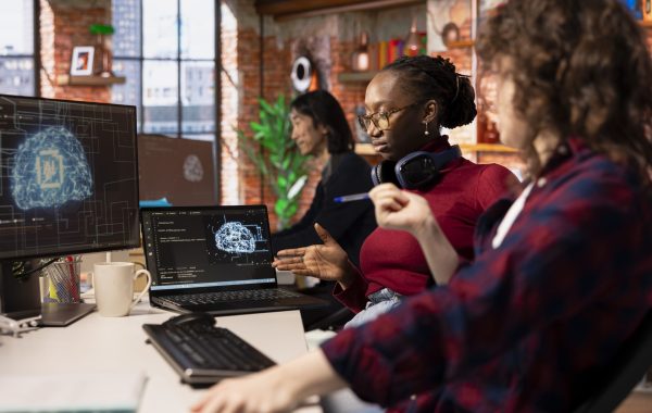 Teamworking startup technicians cooperating to do rapid technological advancement in AI industry. Silicon Valley company colleagues leveraging deep learning tech in workspace to gain competitive edge